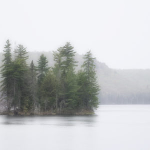 The morning mist rises over a small island in the middle of Tim Lake